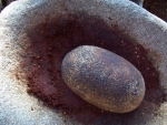 Stone grinding cacao into instant fudge on an ancient Piedra